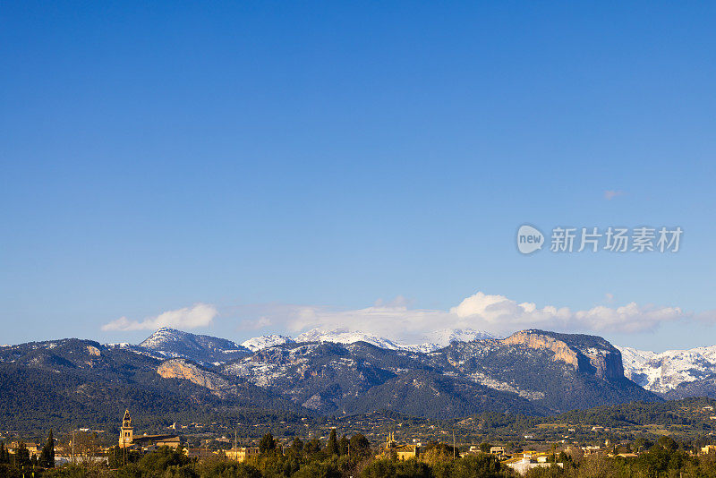 从远处可以看到小村庄Santa Maria del camí后面雪山的美丽景色